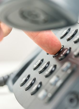 Person drückt Taste auf einem Telefon.